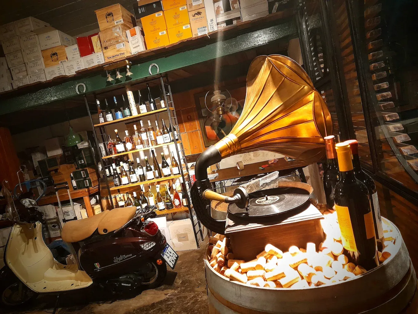 Interior de la cava con gramófono, barril de corchos y estanterías de vino