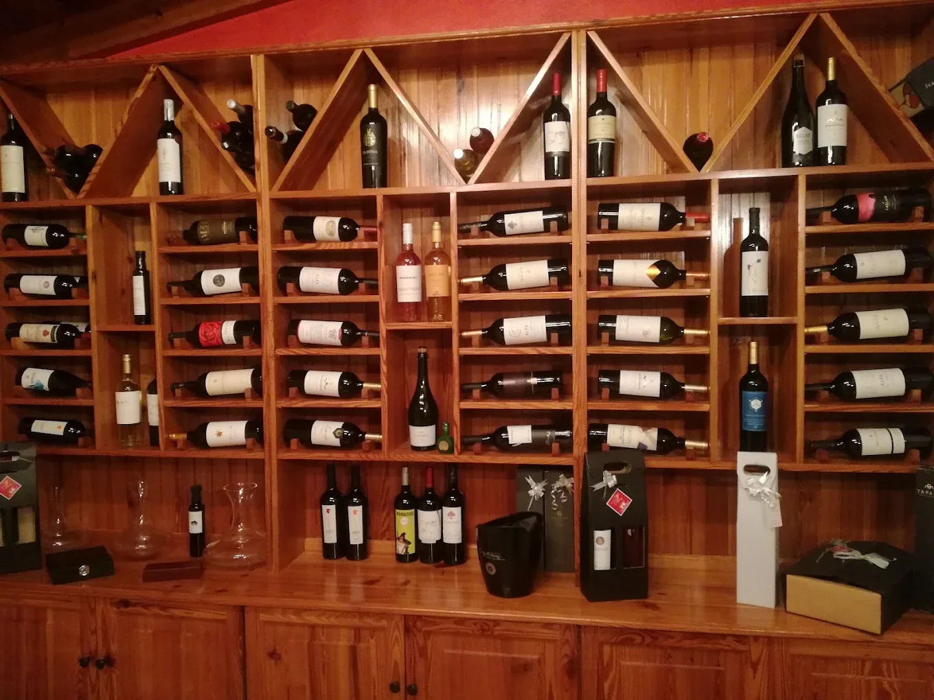 Estantería de madera con decenas de etiquetas de vino en la cava